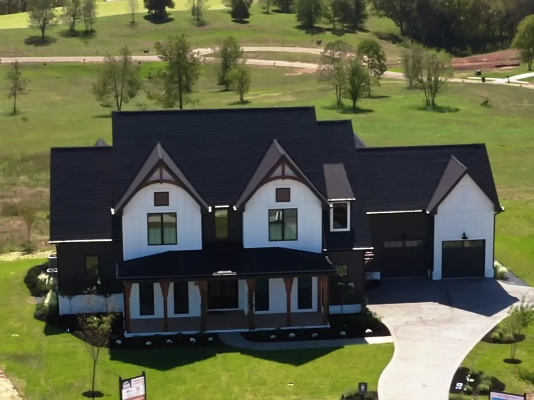 The Modern Farmhouse, a white board-and-batten home with black windows and a metal roof